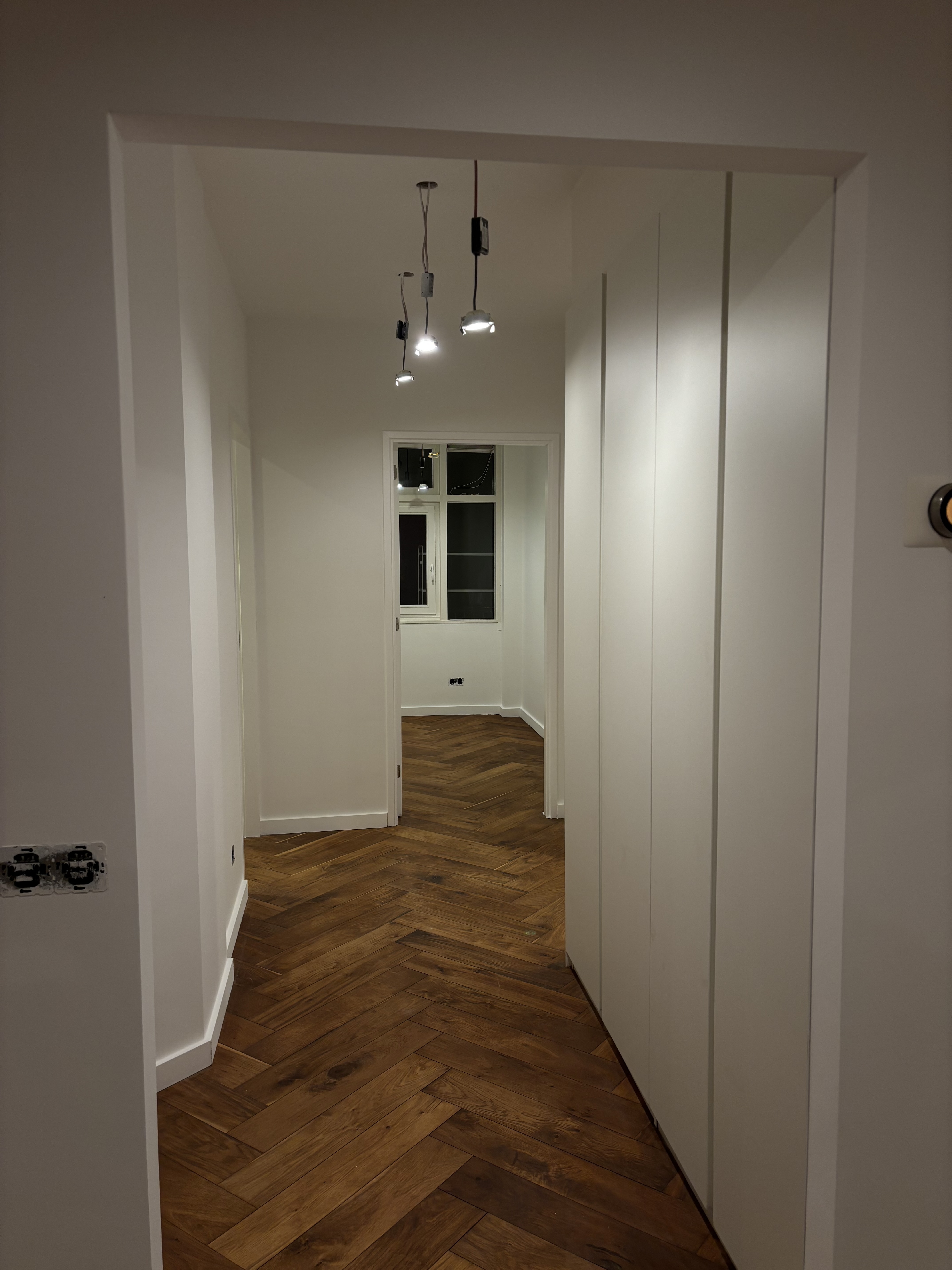 White hallway with herringbone floor