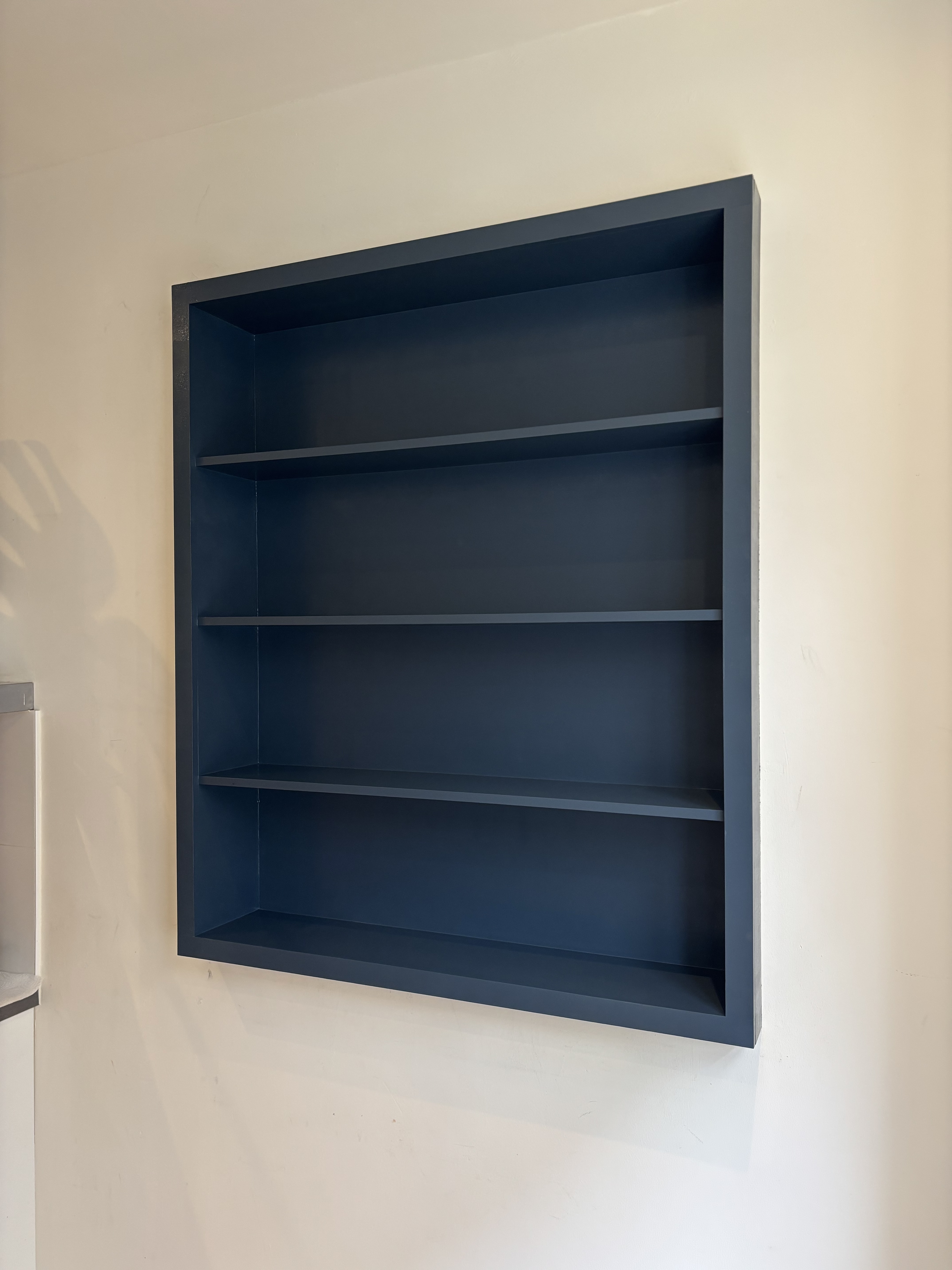 Navy blue painted built-in shelving
